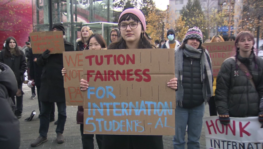 person stands holding cardboard sign