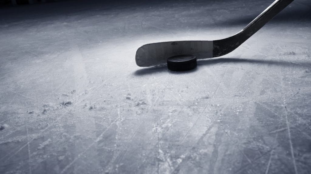 A hockey stick on ice with a puck