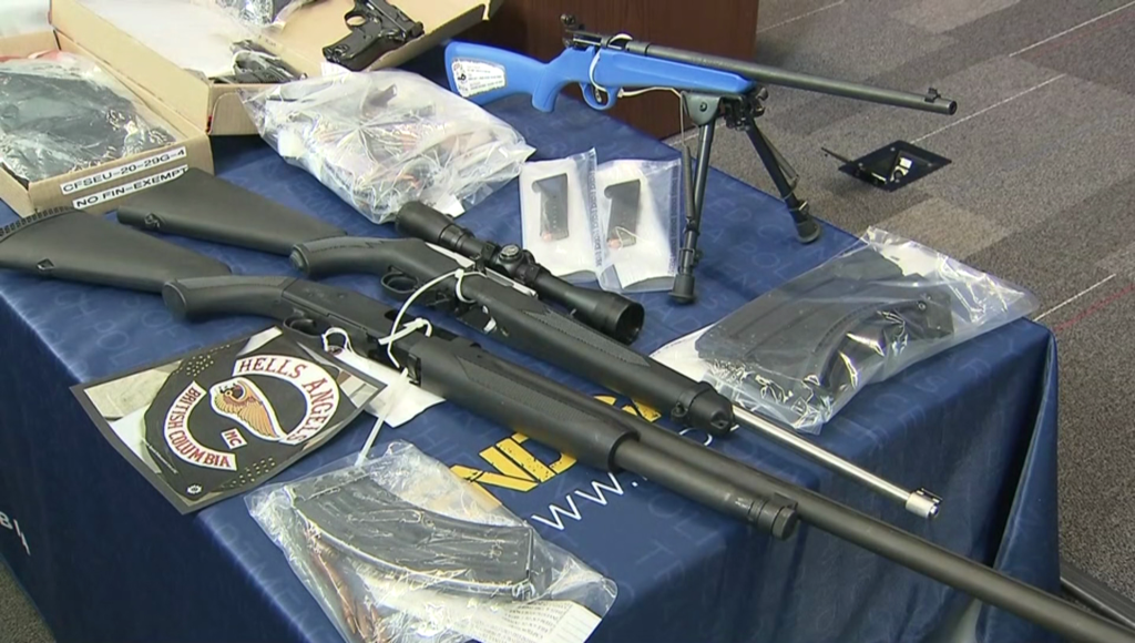 Combined Forces Special Enforcement Unit of B.C. display weapons and drugs on a table at a press conference
