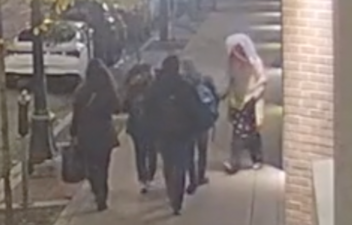 A group of people is seen walking in Vancouver's Gastown neighbourhood as a person approaches them and assaults one pedestrian
