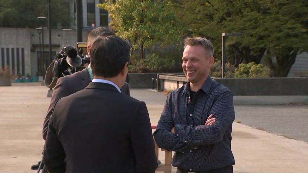 Brian Montague smiles while talking to Ken Sim