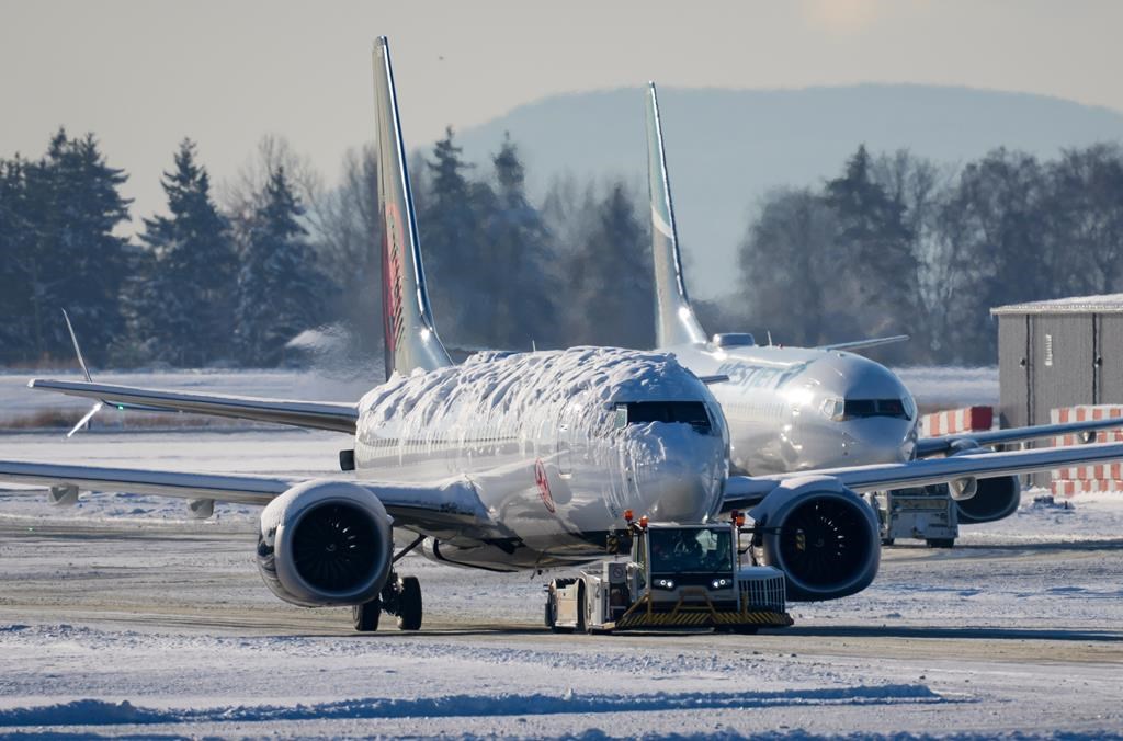 A plane covered in snow at Vancouver's YVR airport.