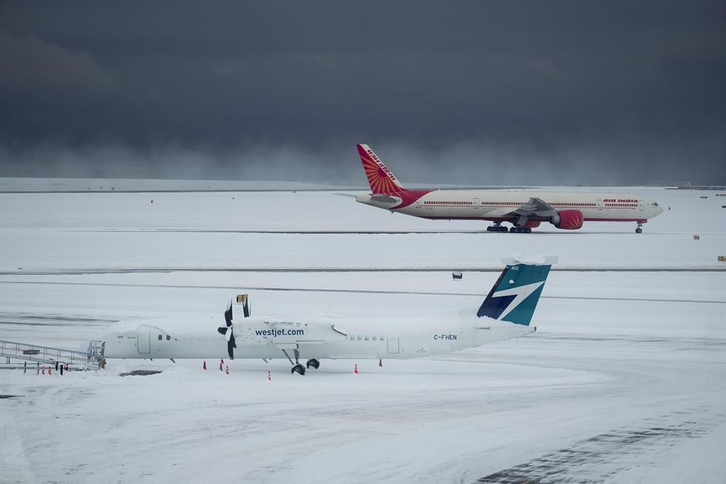 Westjet and Air India aircraft sit idle at Vancouver International Airport after a snowstorm shut down operations leading to cancellations and major delays