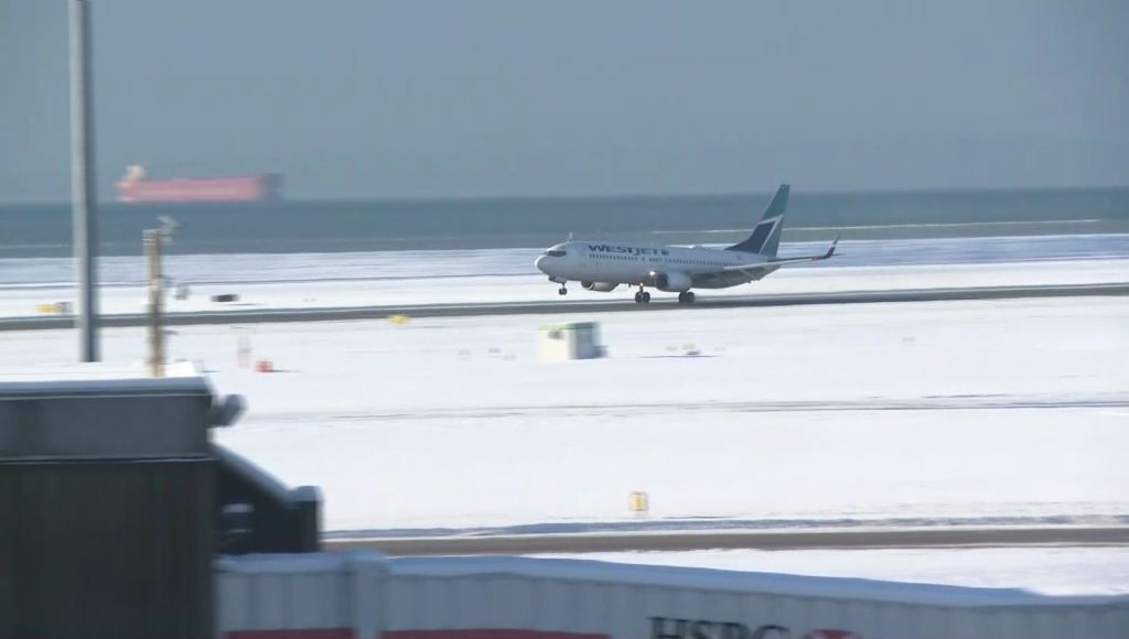 Westjet plane on a snow covered runway at Vancouver International Airport