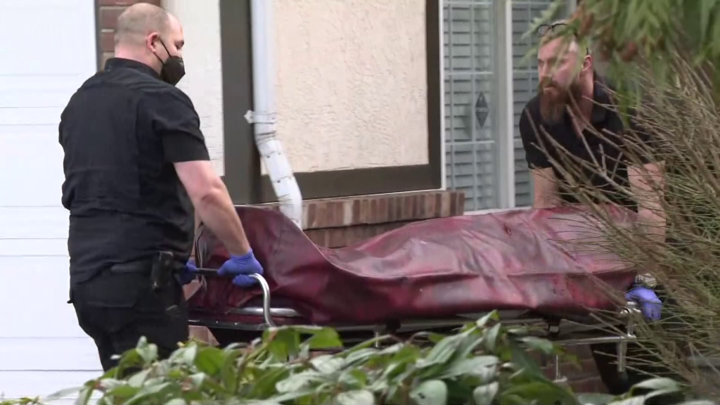 Investigators removing one of three bodies from a Surrey home