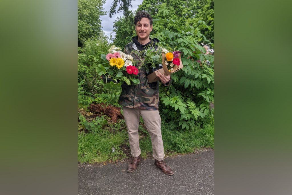 Vancouver renter Michael Ianni stands outside holding flowers in both hands. Michael says he's being forced from his apartment due to rental rules related to roommates service notice to end tenancy