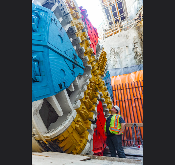 a construction worker stands in front of a large circular machine
