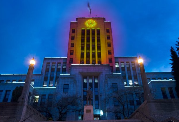 vancouver's city hall is illuminated in yellow