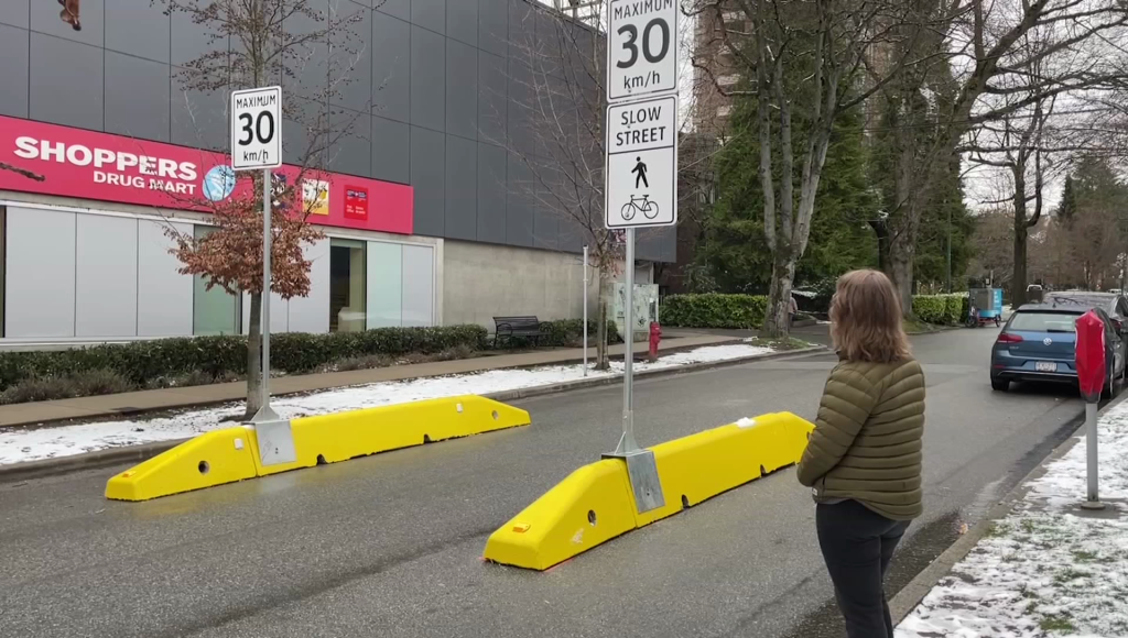 Slow street sign in Vancouver with person in foreground