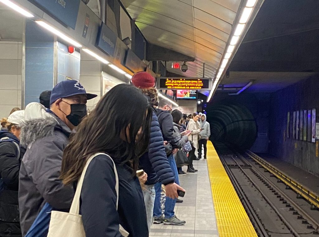 people standing and waiting at a skytrain station