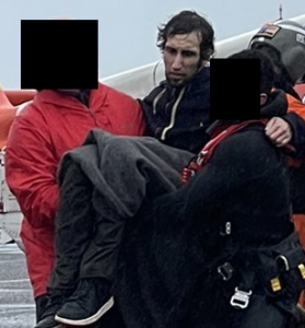 Jericho Labonte is shown on a boat in the arms of coast guard rescuers.
