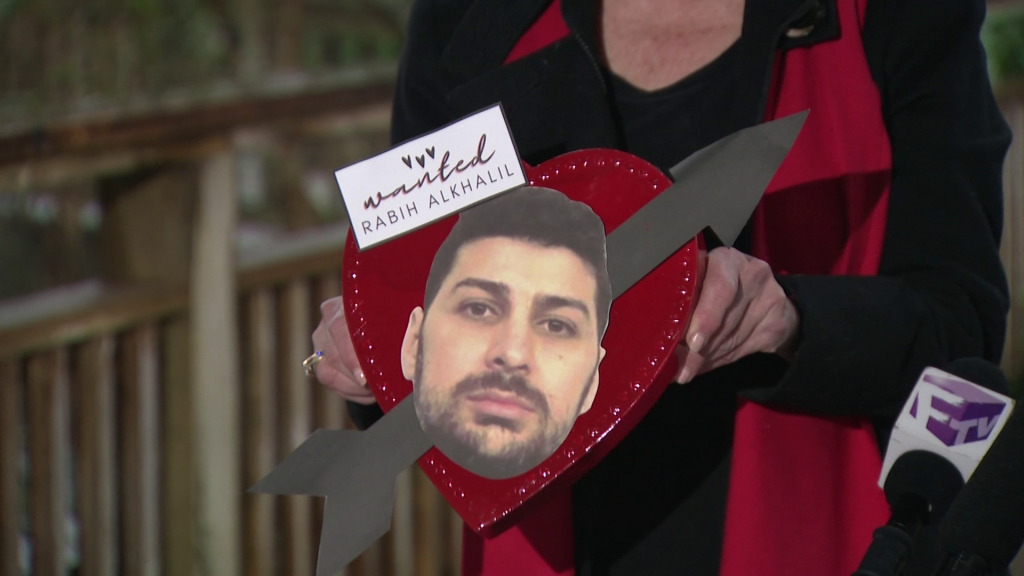 a heartshaped cutout with the face of a wanted criminal on it