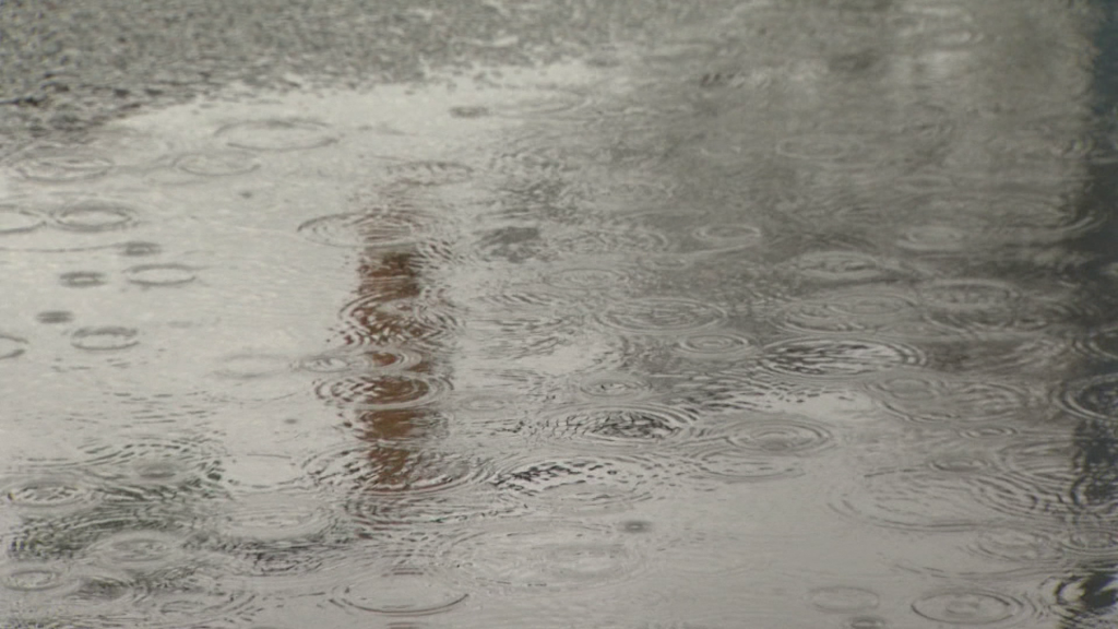 A puddle with raindrops falling on it during a storm in Metro Vancouver