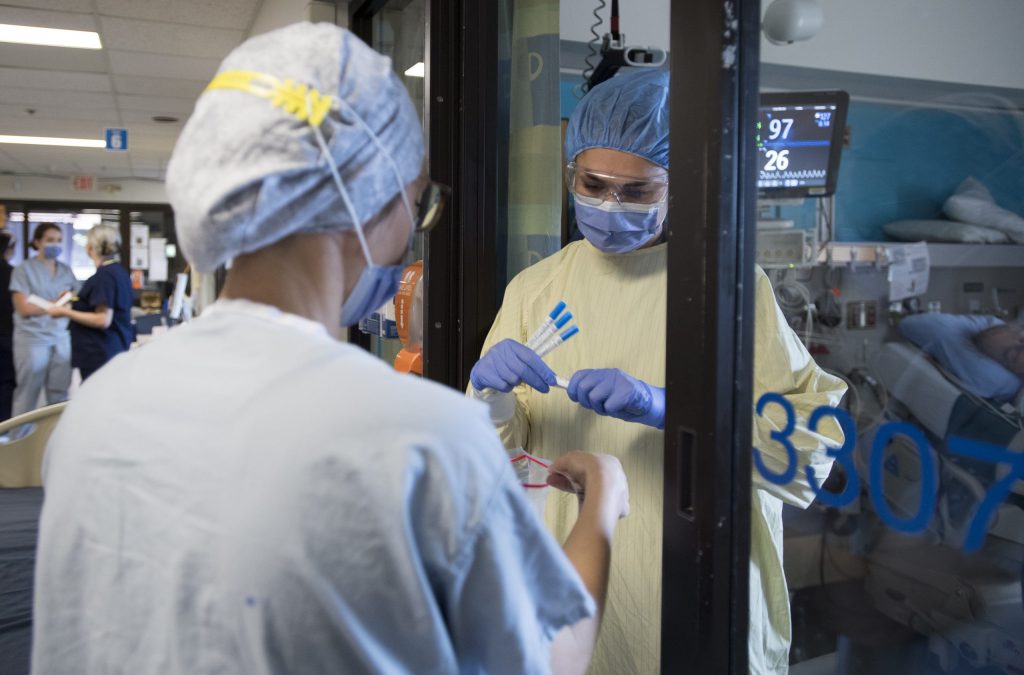 nurses in scrubs collecting COVID samples