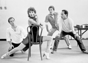 Raquel Welch sitting on a chair surrounded by three men