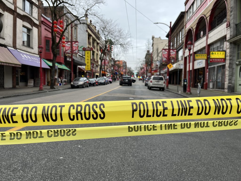 A police cruiser blocks a street in Vancouver's Chinatown with crime scene tape