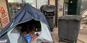 DTES tent with garbage bins surrounding it