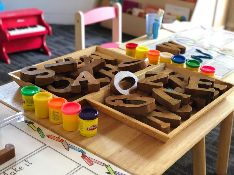 wooden blocks of letters sit on a table at a daycare