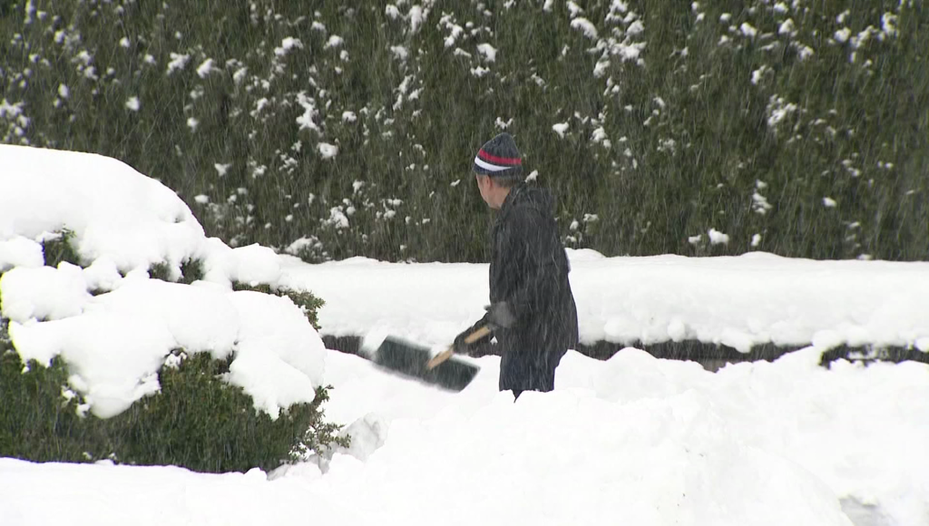 A man shovels snow in Surrey