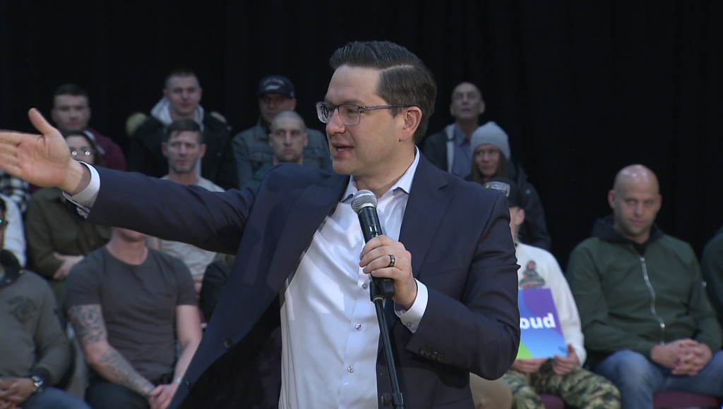 Pierre Poilievre speaks with a crowd behind him