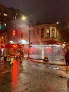 fire at a multi story building coming out of a window