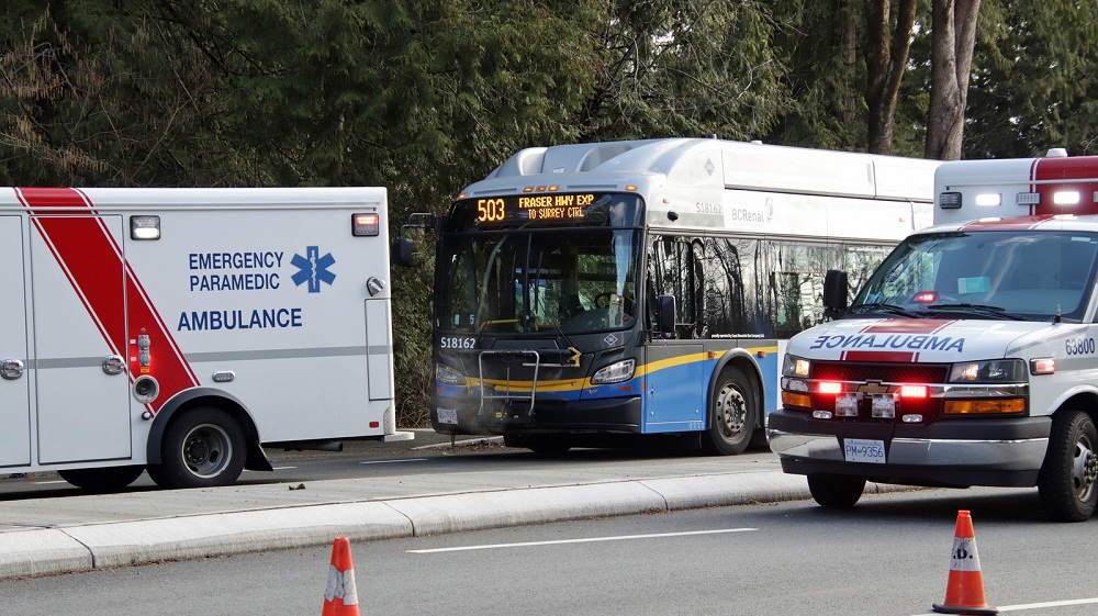 Emergency vehicles are seen near a city bus.