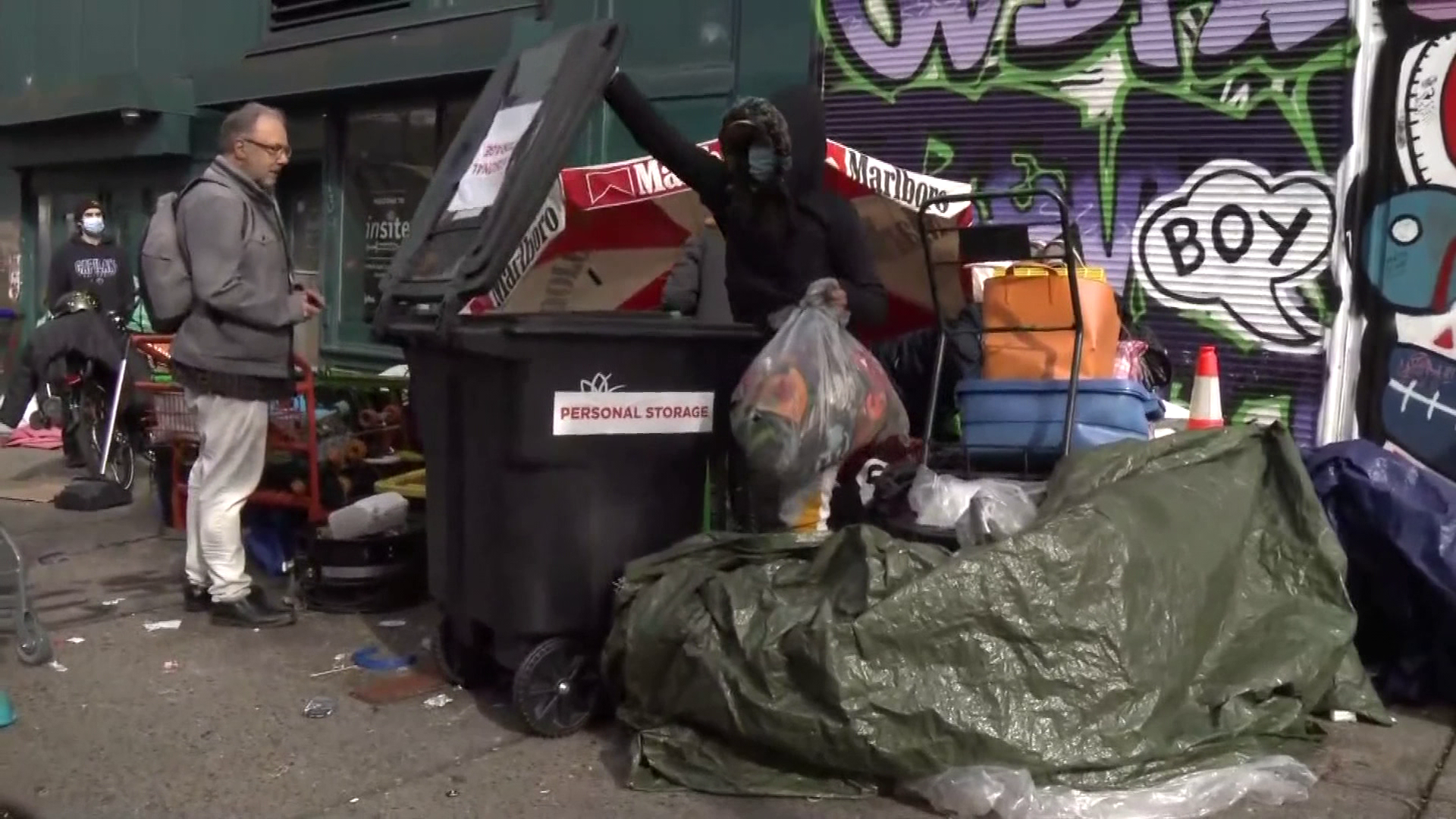 A person on the sidewalk fills a personal storage bin