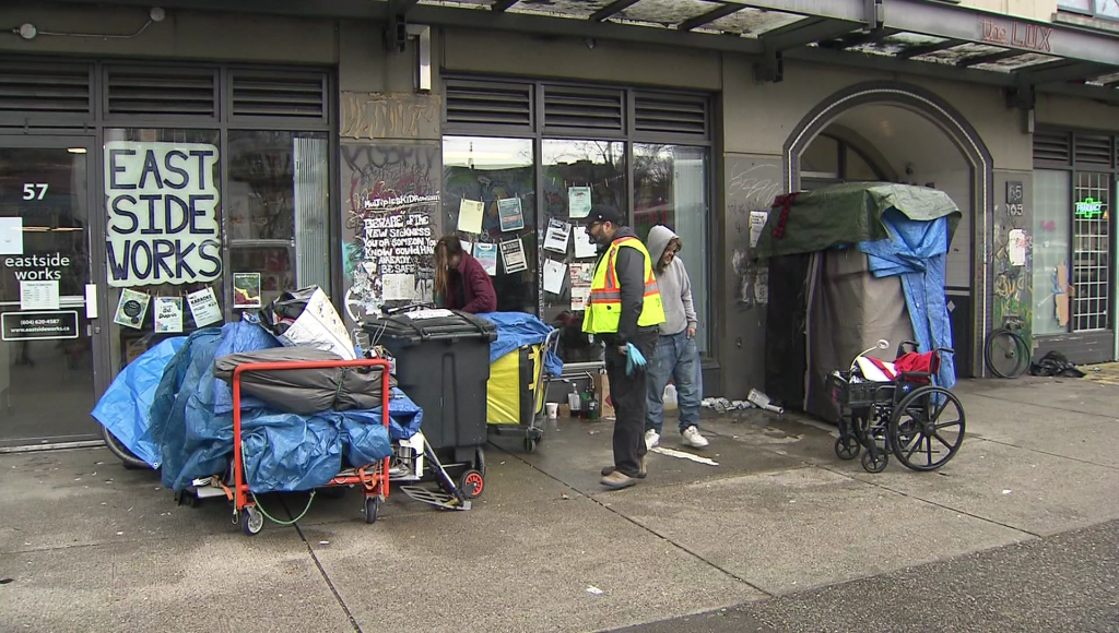 A view of East Hastings Street as City of Vancouver workers and VPD are on site to clean up an area of sidewalk