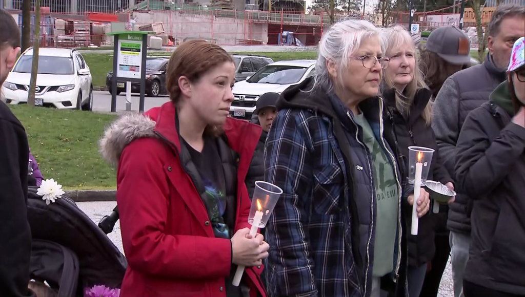 Famiyl and friends gather on a field in Surrey for a candle light vigil