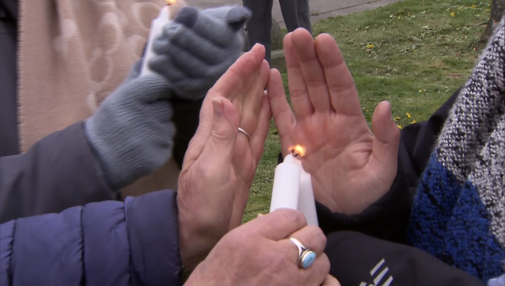 Two candles are lit in Surrey at a vigil