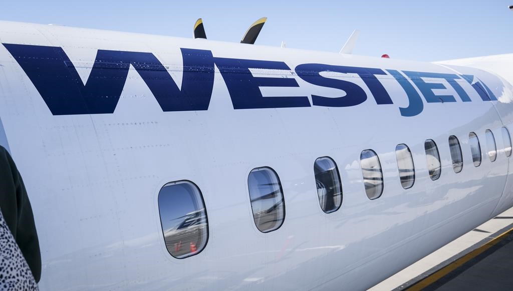 A WestJet plane waits at a gate at Calgary International Airport in Calgary, Alta.