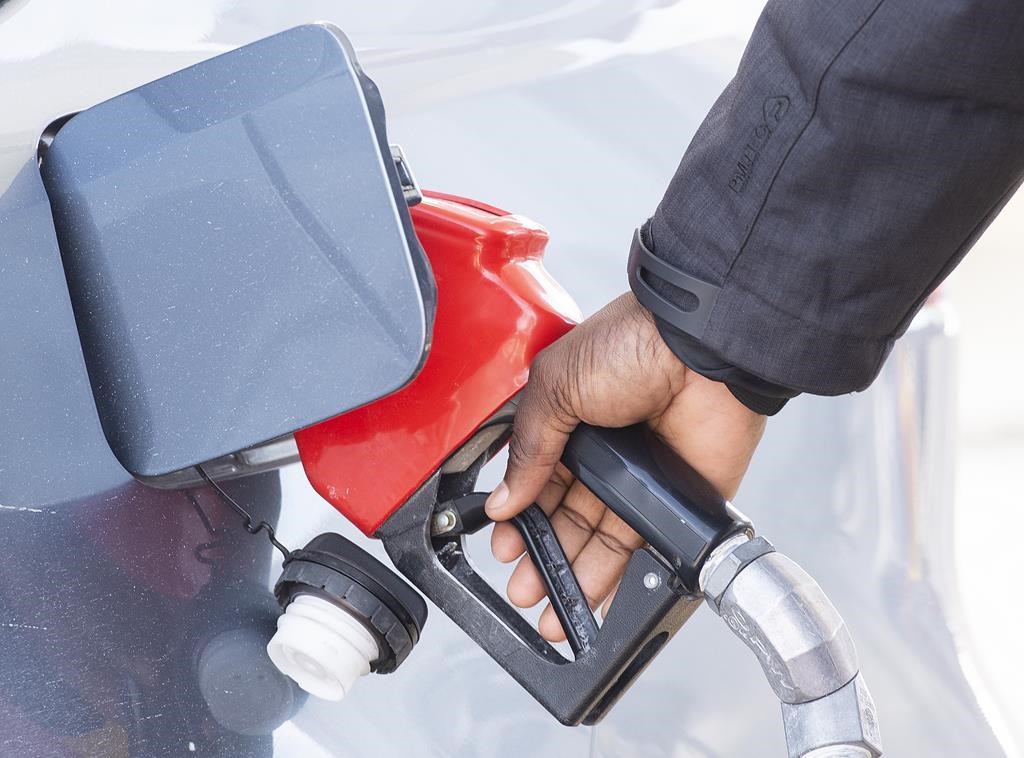 A hand shown pumping gasoline into a vehicle