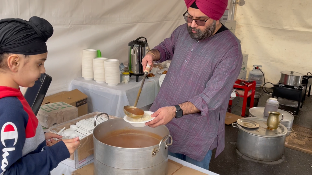 a man is seen dishing out a bowl of food at the annual vaisakhi parade