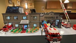 a lego recreation of a surrey fire hall. there is a small fire truck featured/ 2023 BrickCan Lego exhibition