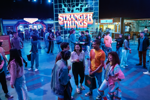 a group of people stand around talking at the stranger things the expereince event, an immersive experince based off the popular netflix show