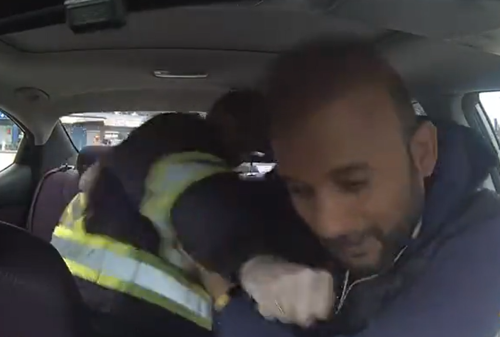 A screenshot of a video showing an Uber driver being punched and then getting into a scuffle with a passenger