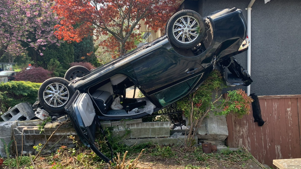 A car flipped on its roof after hitting a home in Vancouver's Langara neighbourhood