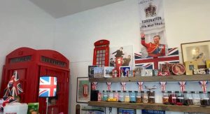 British shop inside a local shop in Metro vancouver shows british goods including a picture of the beatles, a red phone booth and a smiling image of king chalres celebrating his coronation