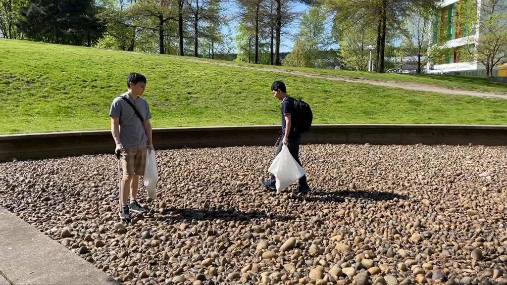 two men with garbage bags walk near a local park in vancouvers chinatwon cleaning up trash