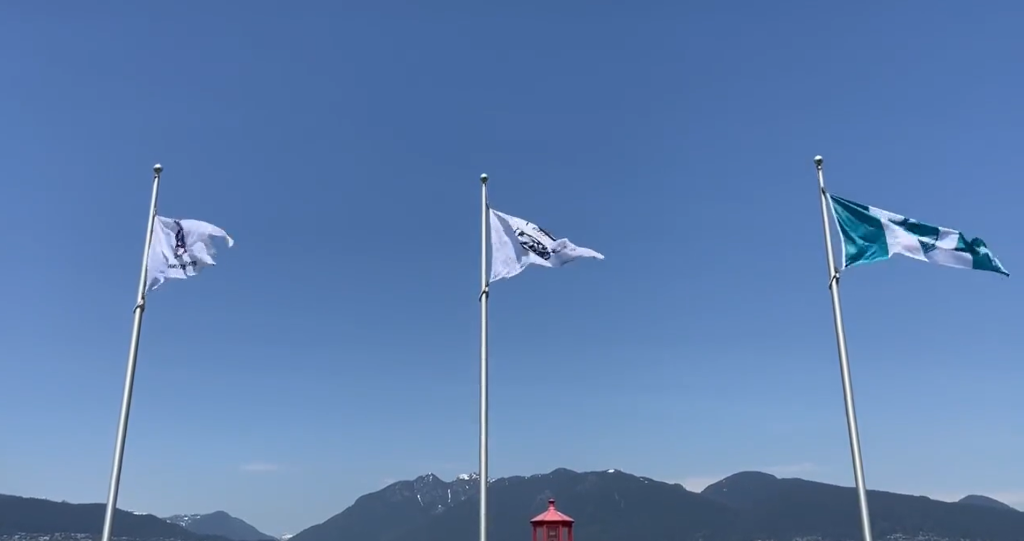 three flags waving on poles at stanley parks brockton point