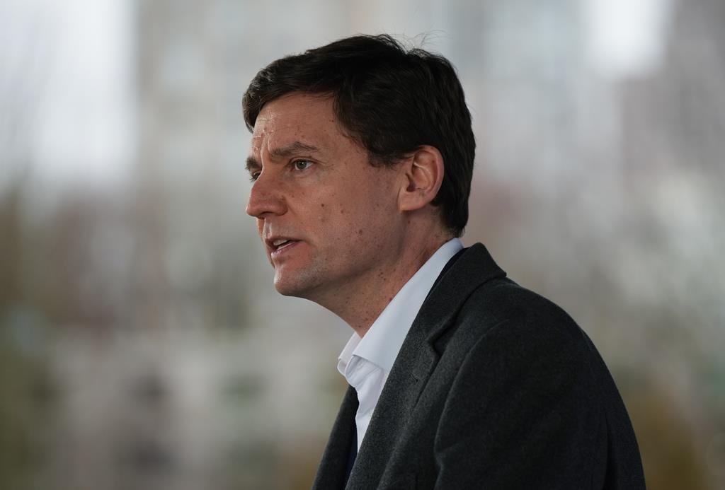bc premier david eby wearing a black suit jacket and white shirt during a news conference in vancouver
