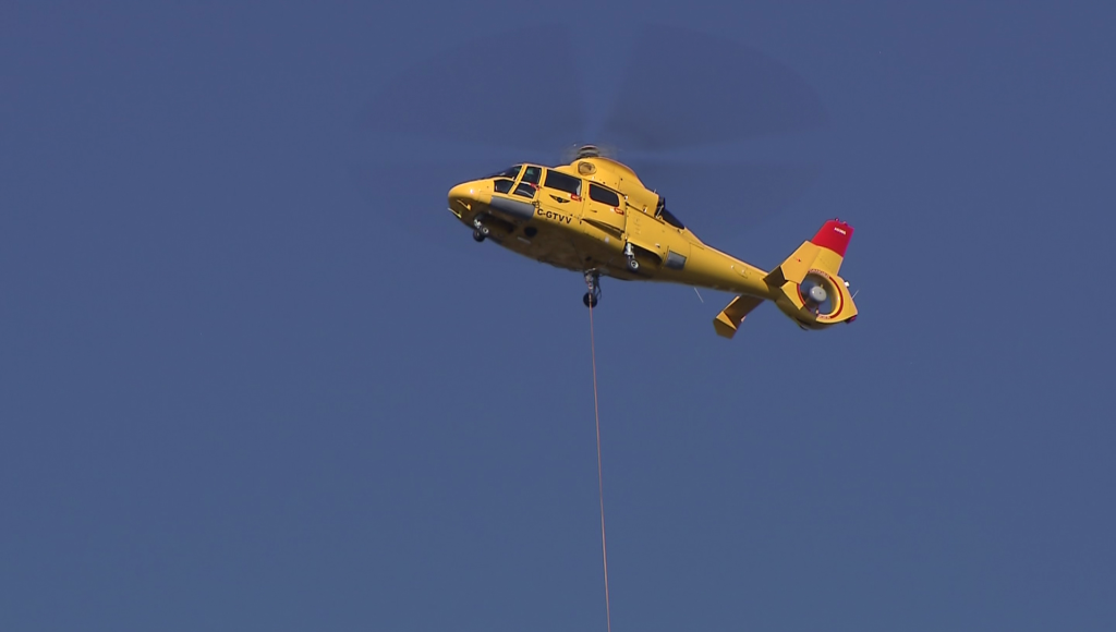 A helicopter removes the Shaw signage from a tower in Coal Harbour
