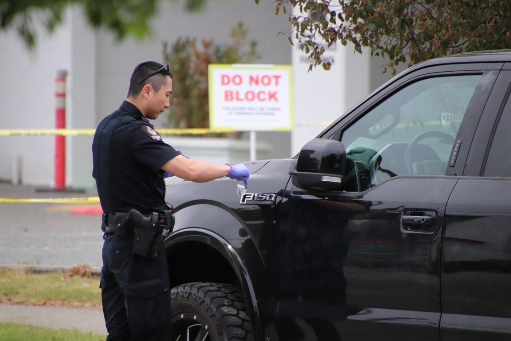 a police officer seen brushing a police cruiser at a crime scene