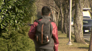 a child walking with a backpack down the street