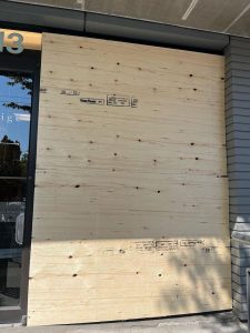 Mila and Paige a botique store front boarded up after a break-in