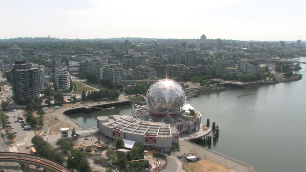 A wide view of Science World and False Creek in Vancouver with smoky skies