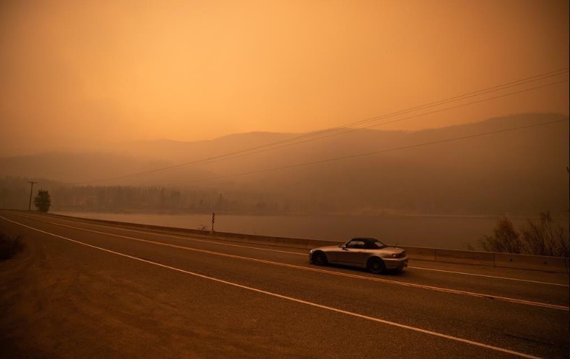 a yellow orange sky is full of smoke due to the donnie creek wildfire burning in bc