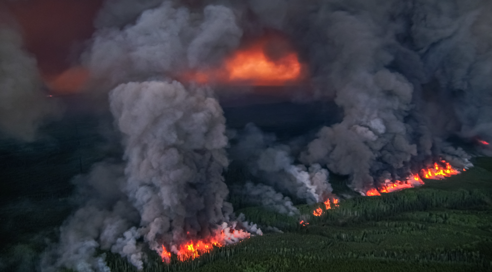 black smoke and ash with vibrant orange flames. the donnie creek wildfire is now the largest in the provinces recorded history