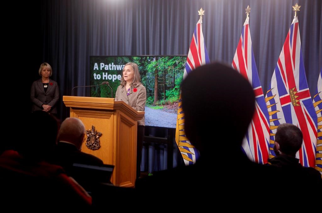 Provincial health officer Dr. Bonnie Henry looks on as chief coroner Lisa Lapointe discusses details about the province's application for decriminalization in the next step to reduce toxic drug deaths during a news conference in the press gallery at the legislature in Victoria, Monday, Nov. 1, 2021