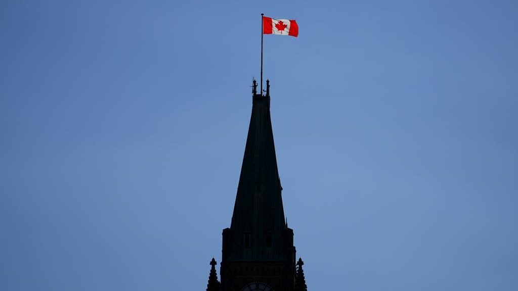The Canada flag on the Peace Tower is lit up by morning light on Parliament Hill in Ottawa